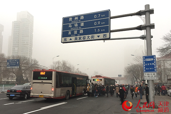 12月20日7:45，天津主干道德才里公交站乘客明显增多。孙晓川/摄