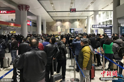 12月20日清晨，北京，受大雾天气影响，首都机场多个航班出现延误、取消等情况，退票改签的乘客在首都机场航站楼前排起了长队。图片来源：视觉中国