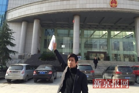 今天上午，汪深兵手举不起诉决定书，走出景德镇市人民检察院。新京报记者 刘子珩 摄