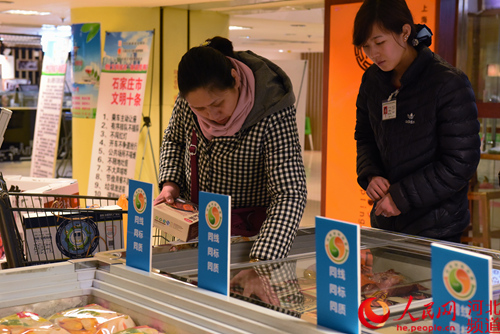 图为顾客在“三同”展柜前选购商品。王雅洁 摄