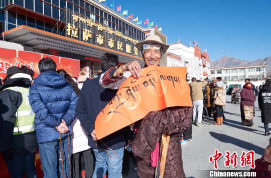 图为1月22日，拿到藏文春联的市民们。　何蓬磊 摄