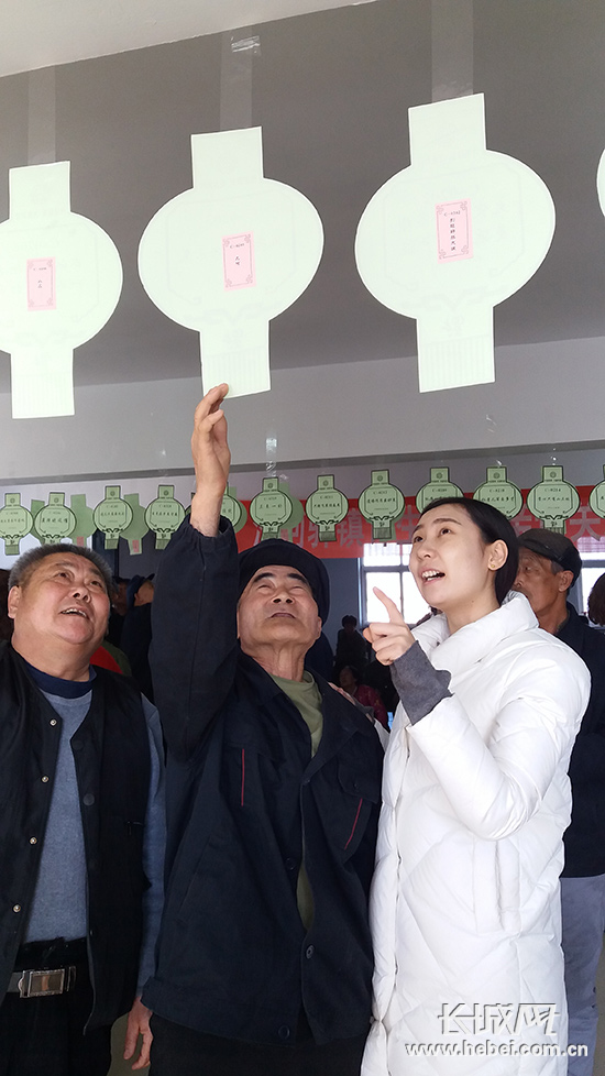 青年志愿者們和老人們一起猜燈謎。李瑛 攝