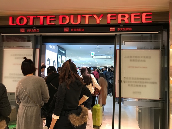 19日，首尔小公洞乐天免税店里，中国游客排队结账。　　