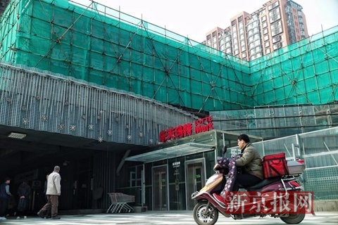 　　东湖渠附近的乐天超市的上层建筑正在施工，建筑上乐天玛特超市的广告牌被绿色的纱网遮住。