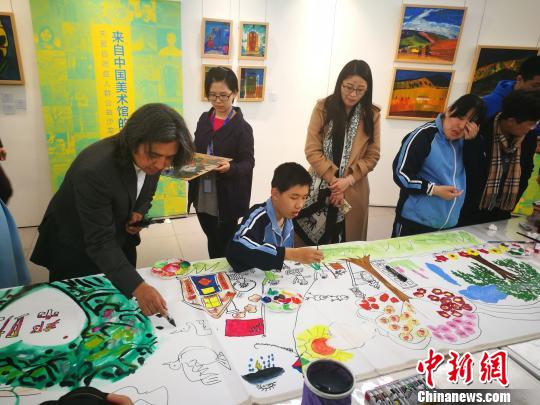 中国美术馆馆长吴为山（左一）与自闭症孩子现场共同创作《春天》　应妮　摄