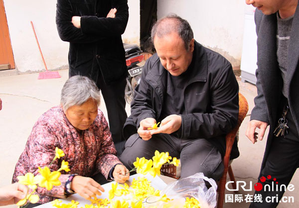 奥古斯托在邯郸大名县赵庄村跟薛俊芳奶奶学习做手工花。