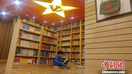 一名男童独自坐在井冈山“红色书店”的地板上读书。华山 摄