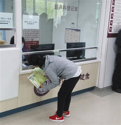 网友拍摄到阜外医院一处门诊窗口前有人弯腰办事。网络图片