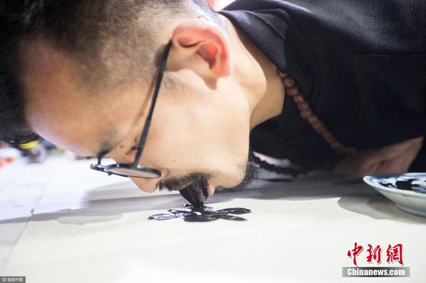 2017年4月26日，浙江省杭州市，一位民间艺术家用舌头代替画笔在纸上作画，引来众多观众围观。不到二十分钟，这位民间奇人就完成了他的舌画作品《一代天骄》，画的是牡丹。图片来源：视觉中国