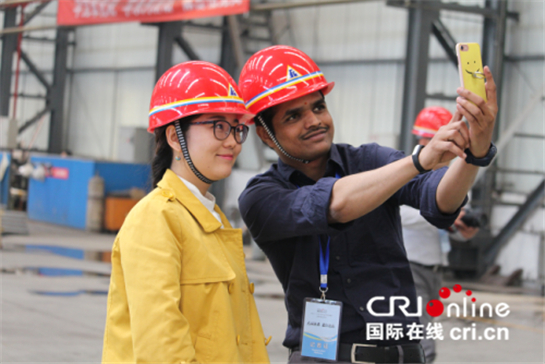 　　来自印度的中国国际广播电台外籍记者那丹与同行记者合影，纪念头戴安全帽的影像（代红玉 摄）