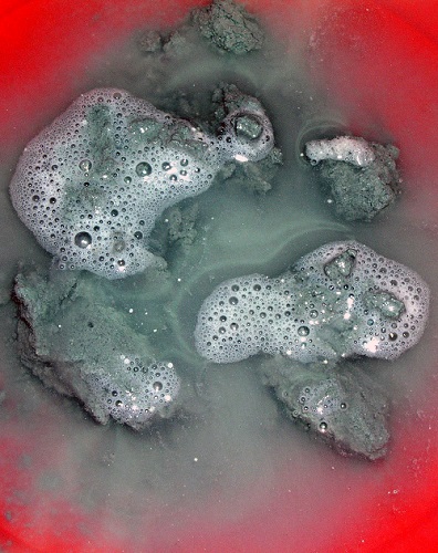 资料图片：夹杂着白色颗粒状“可燃冰”的海底沉积物放入水中随即冒出大量气泡。新华社发