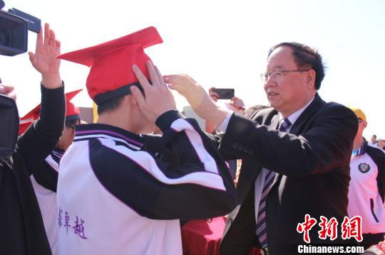 衡水中学校长张文茂为学生冠戴“成人帽”。　张艳春摄