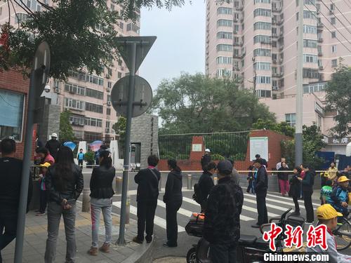 北京西城区一所小学外，不少家长正在等待孩子放学。汤琪摄