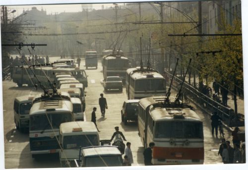上个世纪90年代初期（1992年），青岛市个体小公共开始参与城市客运，公交车小公共同时运行，因为个体小公共乱跑乱闯乱停车，影响公交车正常运行。图为2路、5路电车在中山与小公共拥挤的交通线路。
