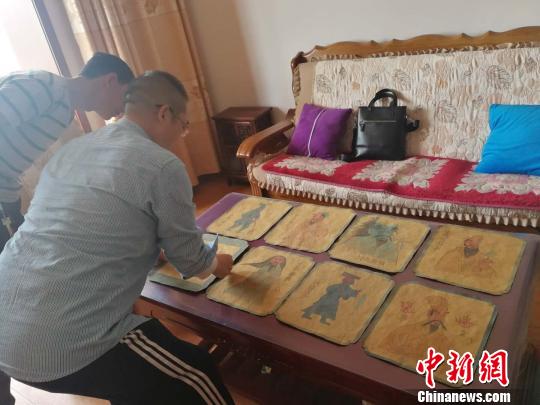 王永忠正在介绍8幅壁画蓝本底稿。　李吉毅摄