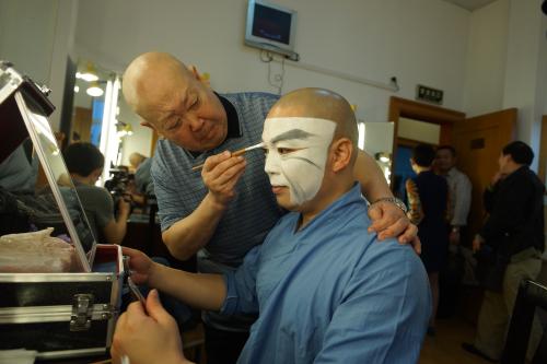 尚长荣正给演员“勾脸”。上海京剧院供图