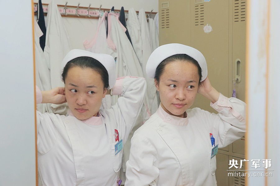 早上7点半，姐妹俩便开始穿戴护士服、燕尾帽，姐妹俩（前为妹妹李梦楠，后为姐姐李梦偲）对戴燕尾帽格外仔细认真。