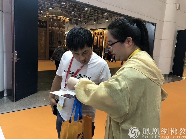 工作人员介绍僧伽医养计划（图片来源：凤凰网佛教）