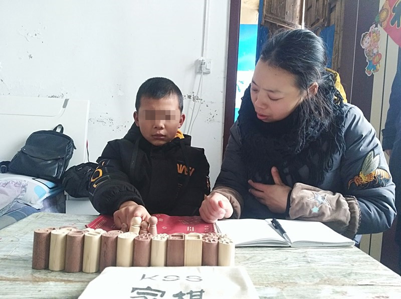 图片说明:“万家无暴”心理咨询师季碧梅到受害人家为孩子做心理治疗