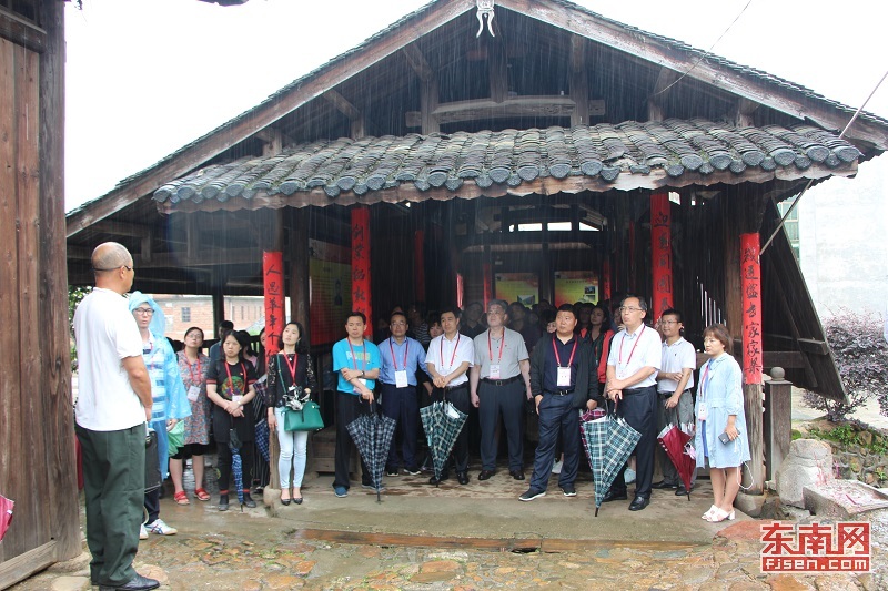 代表团一行在南山镇中复村红军桥上听讲解员钟鸣说历史故事