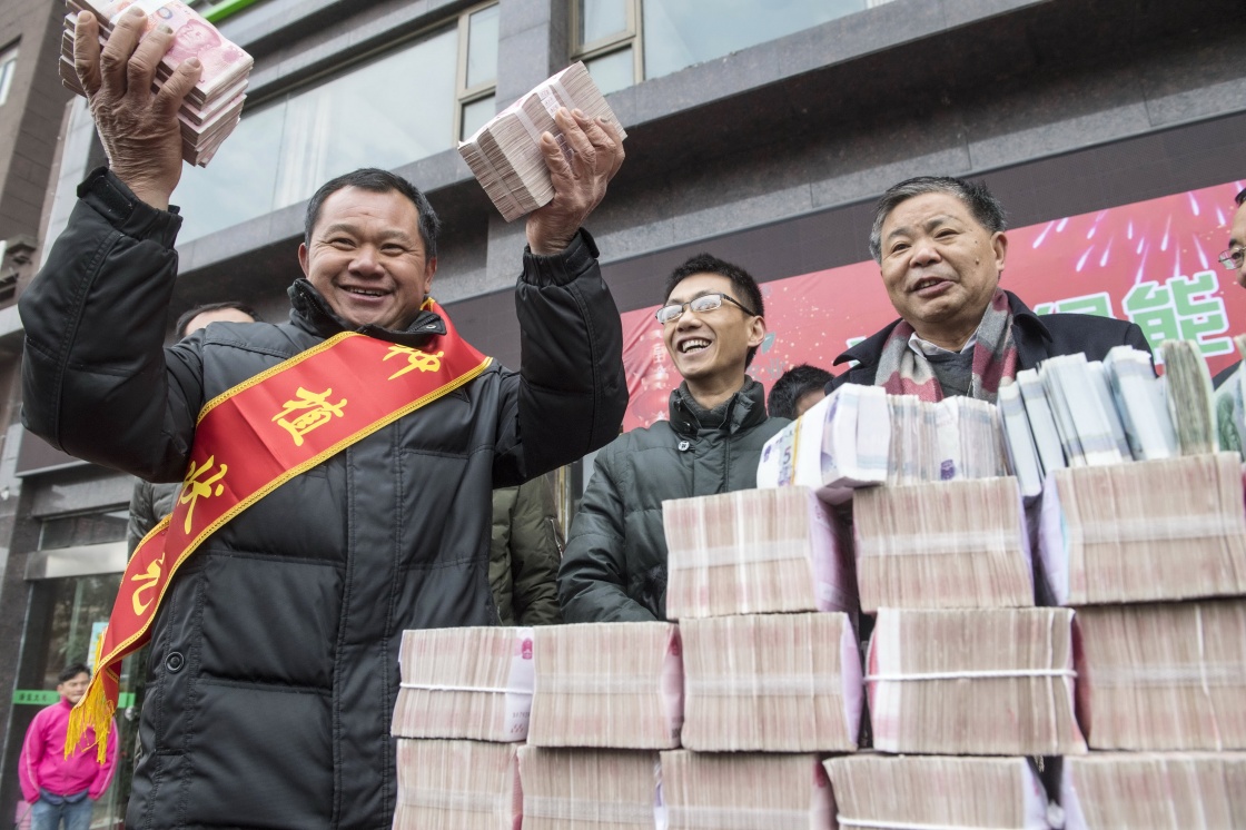 正文1/6 1月8日,个人奖金最高的刘高美(左)手拿着近20万元的奖金向