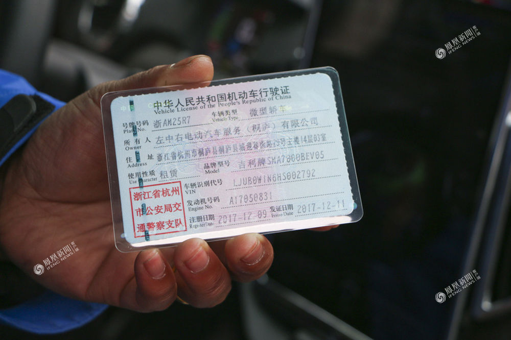 2018年2月11日,浙江桐庐县城,一名工作人员展示共享汽车的行驶证
