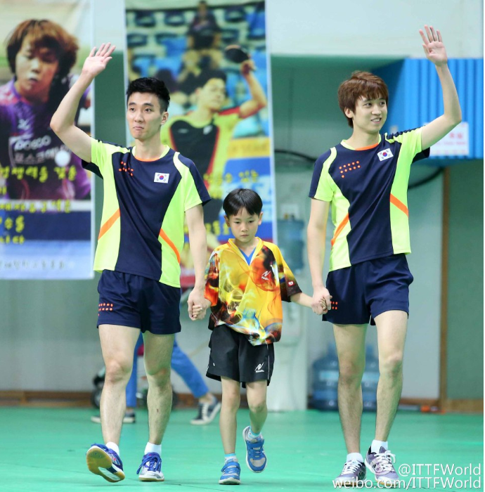 韩国选手郑荣植/李尚洙牵着小球童入场