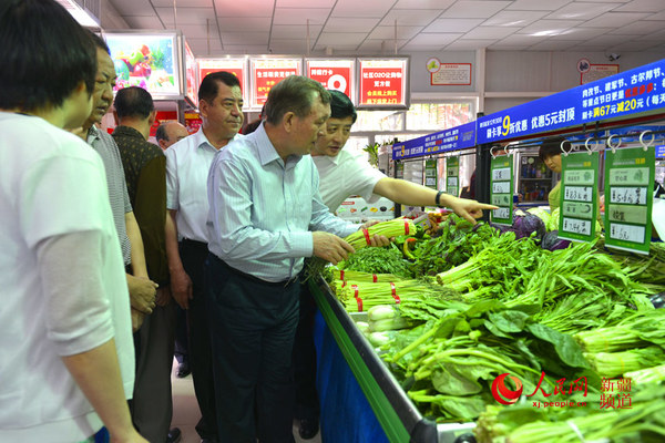 哈尼巴提·沙布开等一行在一家蔬菜销售店走访检查.李晓啸 摄
