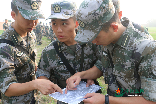 定向越野比赛中,邓琦正给组员讲解按图行进技巧 向宇摄