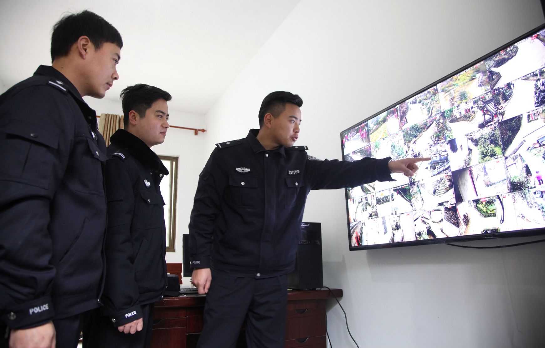 2月13日,安徽歙县雄村镇卖花渔村片警江平(左一)给游客介绍生态保护